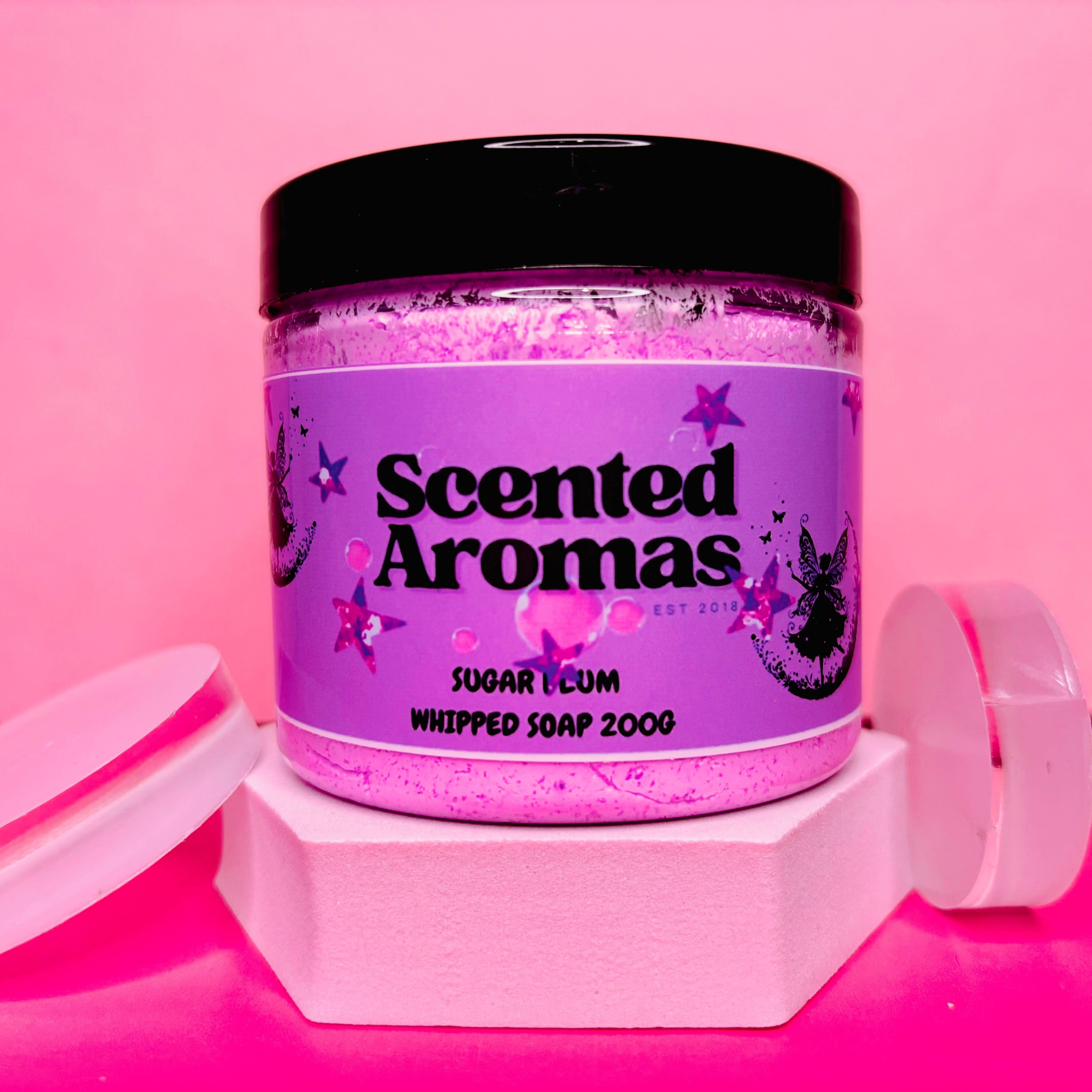 The Mothers Day Gift Set Bundle by Scented Aromas features a delightful display: a 200g sugar plum whipped soap on a pink hexagonal stand, set against a pink background, paired with our Birthday Cake bath bomb. Ideal for any skincare gift set.