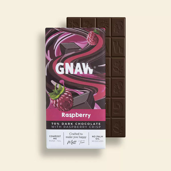 Partially unwrapped, this 70% dark chocolate with raspberry crisp has a wrapper featuring raspberry images and swirling patterns on a light beige background. Its luxurious design perfectly complements the Scented Aromas Self Care Bundle, making it an ideal addition to any pampering routine.