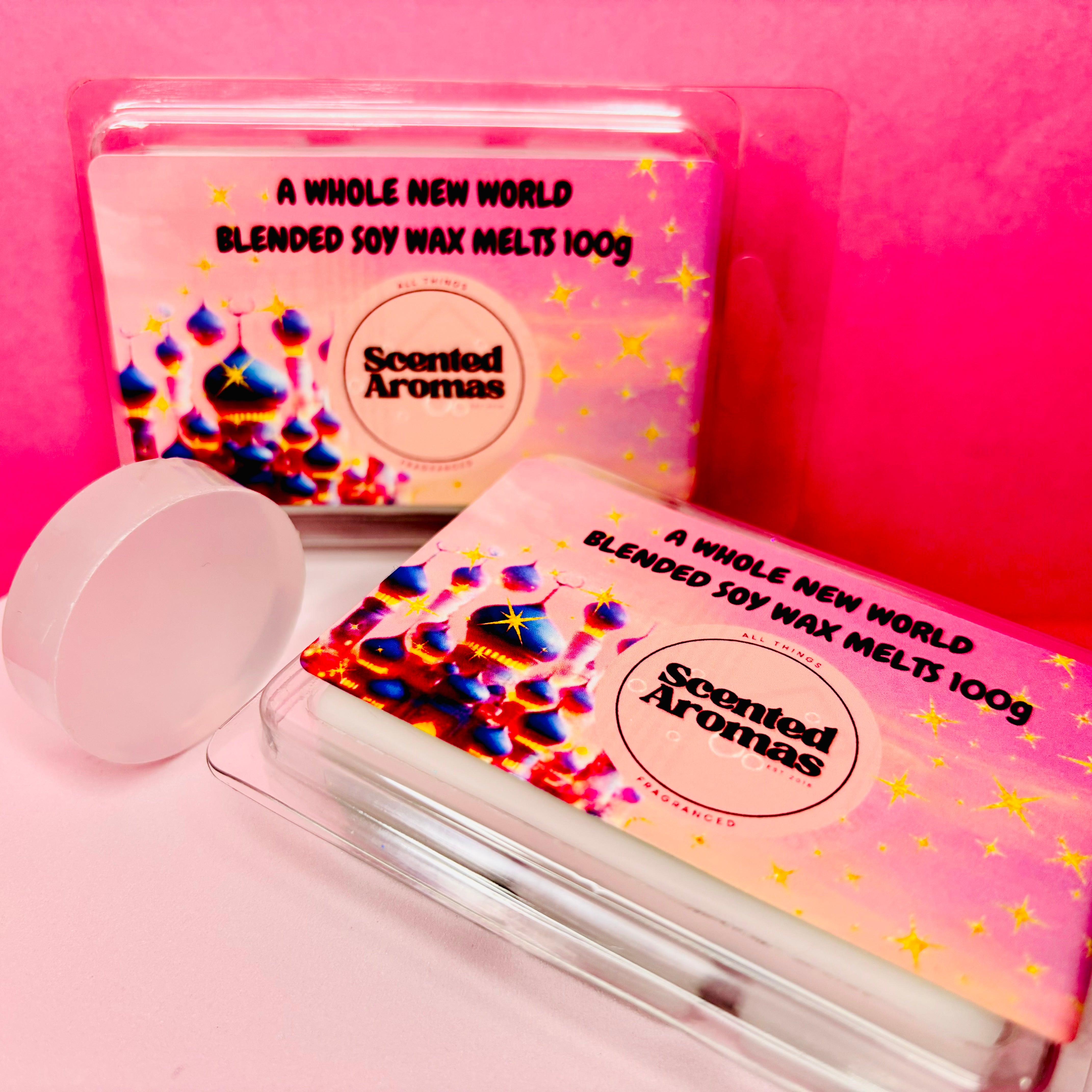 two clamshells of "A Brand New World" soy wax melts by scented aromas are elegantly displayed against a pink background.