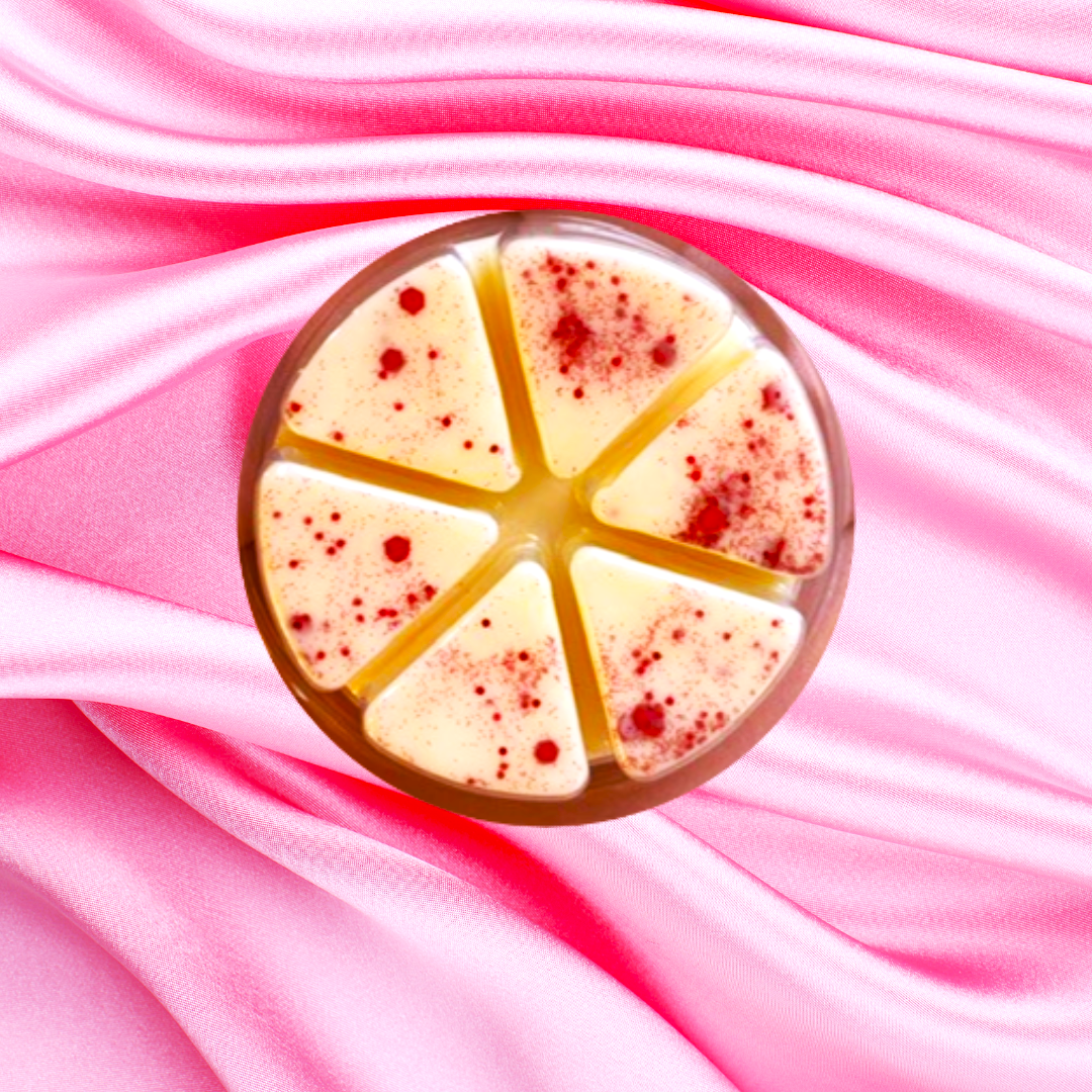 A White Chocolate Covered Strawberries Wax Melt by The Soap Gal x, featuring six triangular slices with red speckles, reminiscent of white chocolate-covered strawberries, is set on a pink satin fabric background.