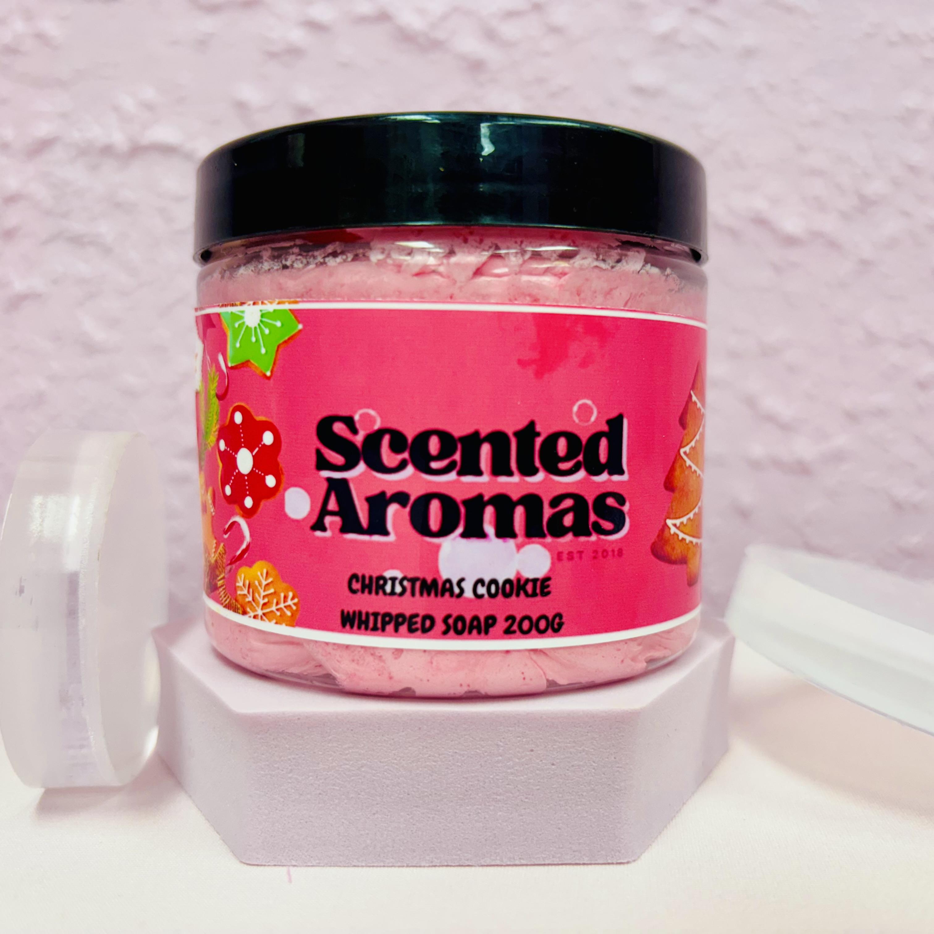 Jar of 'Scented Aromas' Christmas Cookie whipped soap on a white stand with a pink background