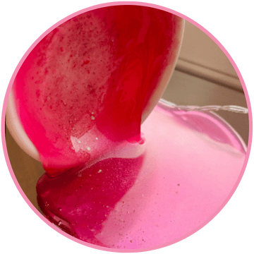 Bright pink and red liquid swirls and bubbles spread across a flat surface, resembling the vibrant Snow Pixie Gel Wax Melts 85g by The Soap Gal x, all handmade in Manchester.